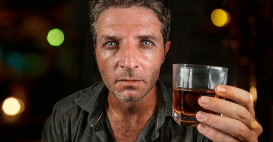 man holding shot glass