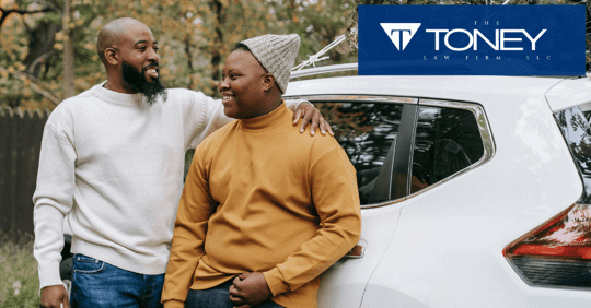 man and his son standing next to car smiling at each other