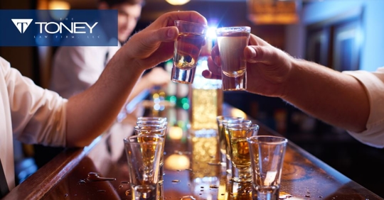 men holding shot glasses up at a bar to cheers