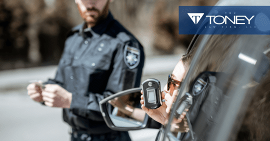 woman taking breathalyzer test out of car window