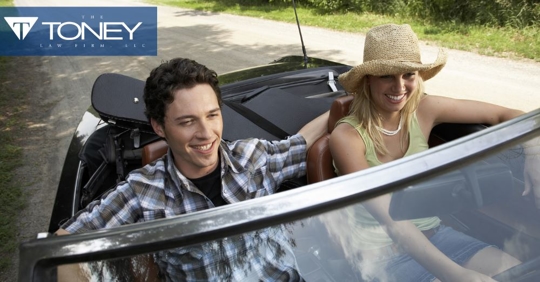 man and woman riding in a convertible together