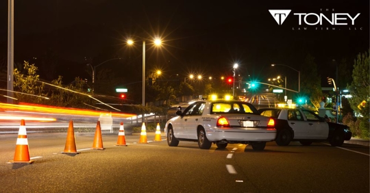 police cars and cones on road at night