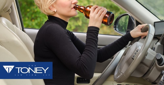 woman trying to drinking beer while driving